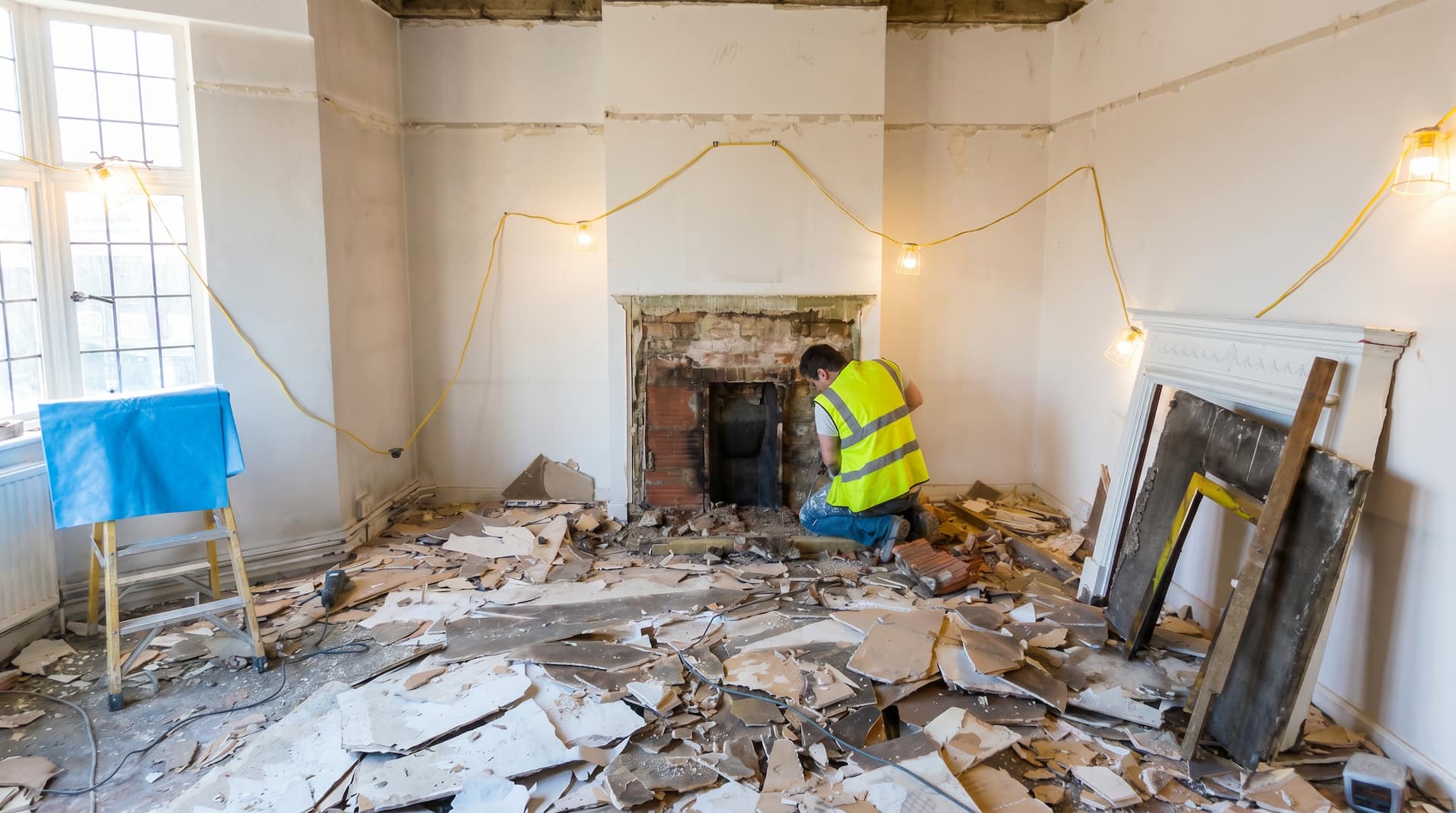 Period reception room stripped back to bare walls and exposed brick fireplace during refurbishment